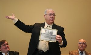 Councilman Bob Weiner holds a photo of the house that once stood at 1306 Foulk Rd as James Hanby (left) and Jack Day (who grew up in the house) look on.